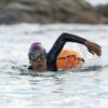 Woman swimming in open water with wetsuit and buoy